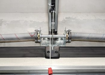 Springs tensioning the home garage door mechanism, view from the inside, visible rail with chain.