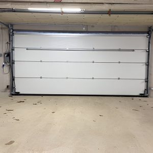 White garage door in a clean, well-lit garage setting, showcasing quality installation and maintenance by Garage Door Repair Fort Myers LLC.